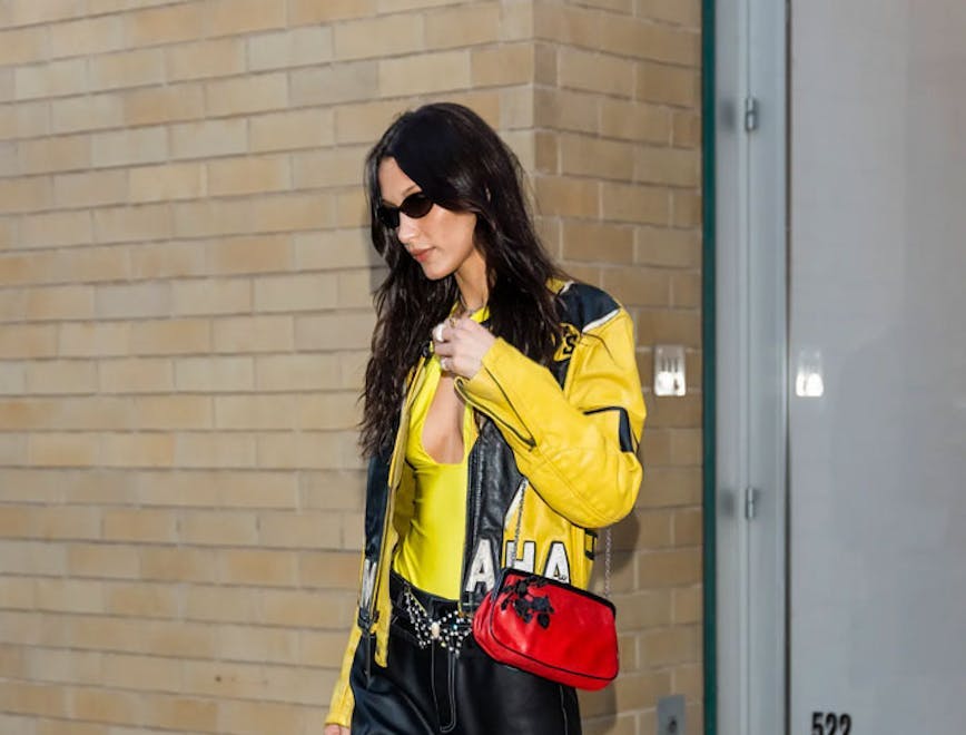 Bella Hadid wearing a yellow biker jacket and black leather pants