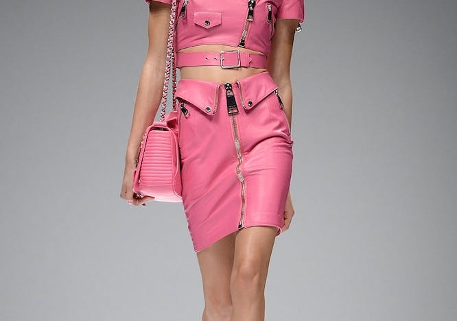 model in matching pink top and skirt holding pink barbie bag