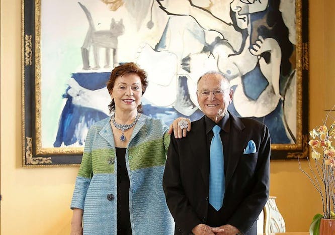 A woman and man standing in front of a painting.