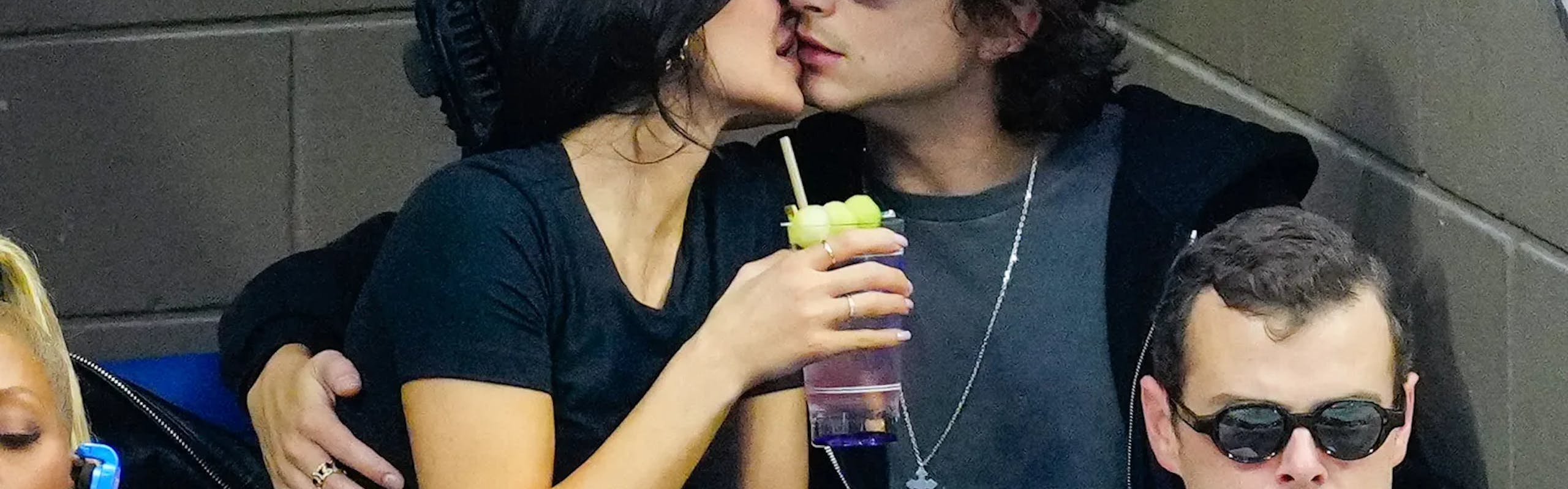 kylie jenner in a black t-shirt and updo kissing timothee chalamet in a black hoodie and grey t-shirt