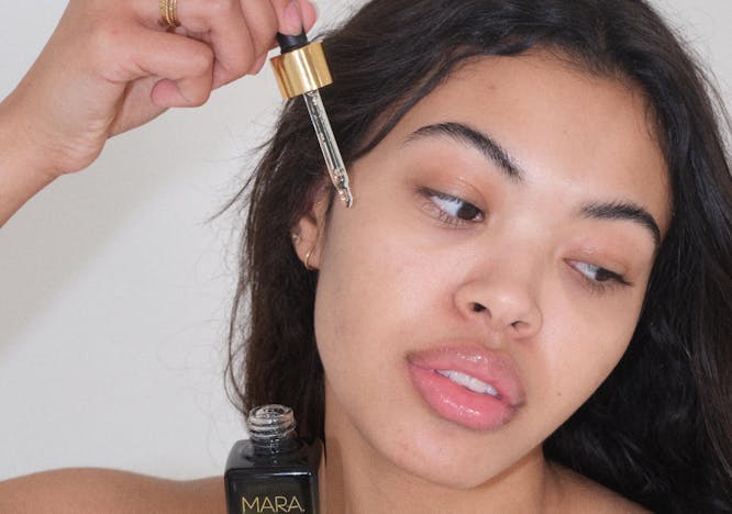 a woman applying mara beauty face oil