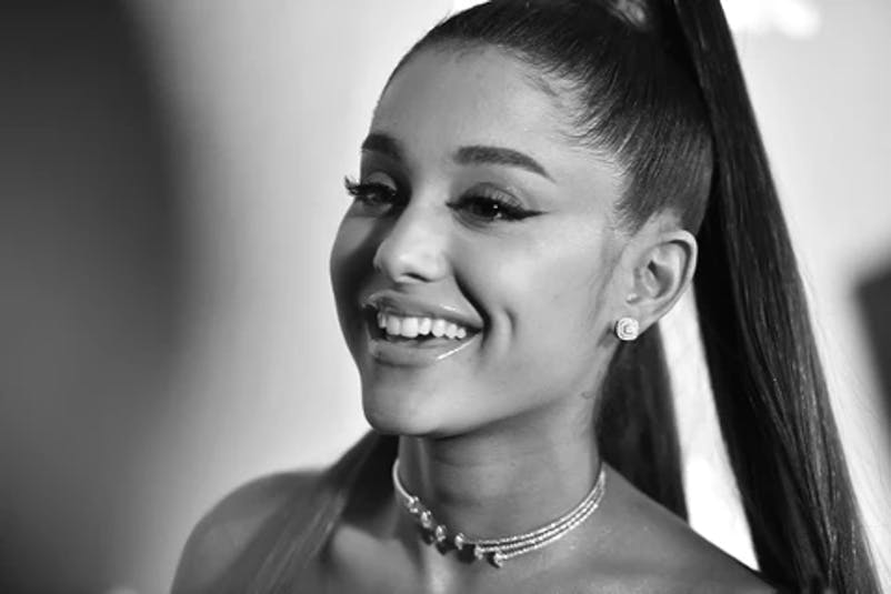 Black and white photo of Ariana Grande smiling.