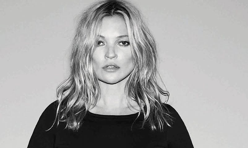 Black and white photo of Kate Moss with messy hair and a black t-shirt