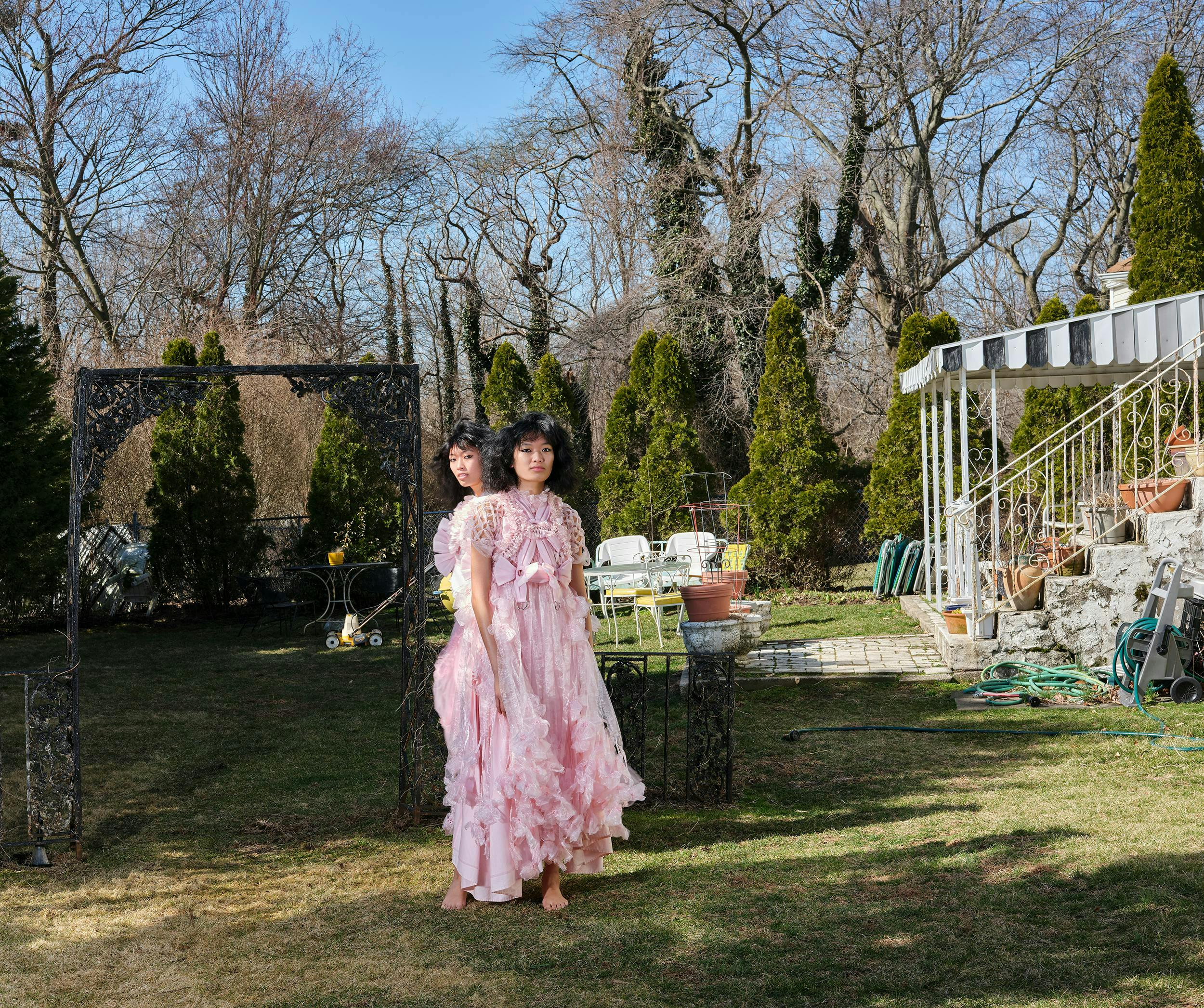 Two models posing amist a garden wearing a garden party dress