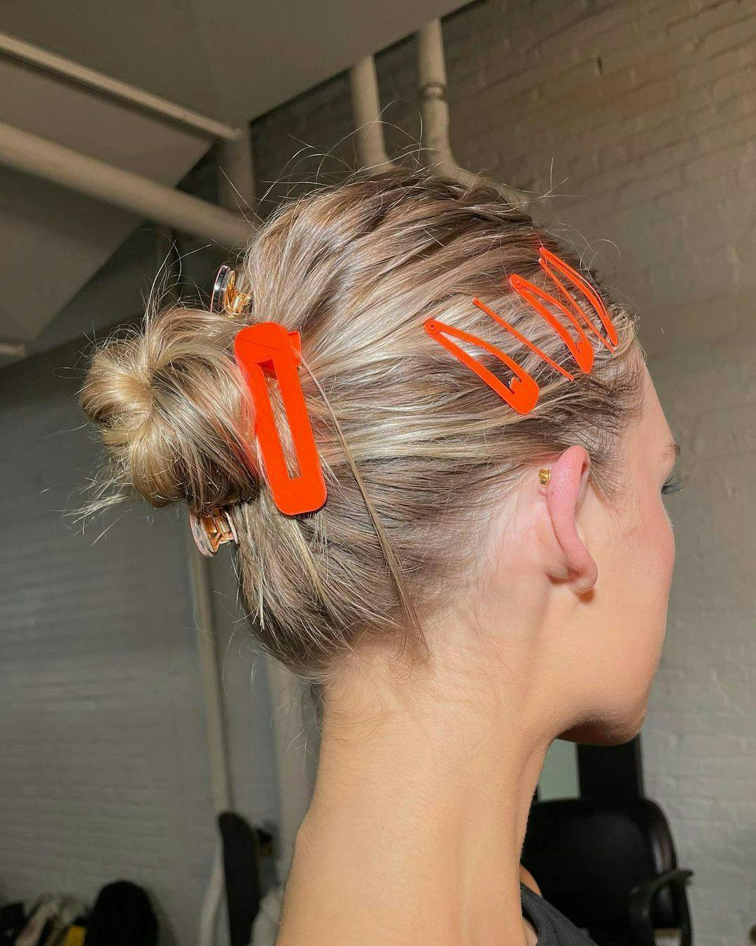 Back of Gigi Hadid's head showing off her bun with neon orange clips