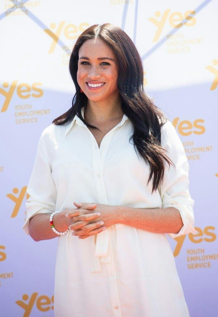 Meghan Markle smiling to the camera.