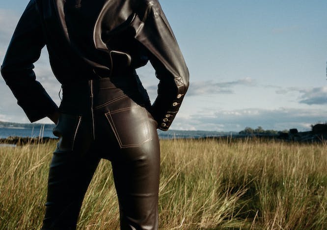 Woman in vegan leather pants in a field
