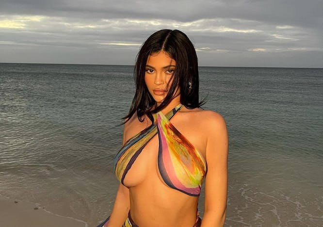 Kylie Jenner showing underboob in a scarf top on the beach.