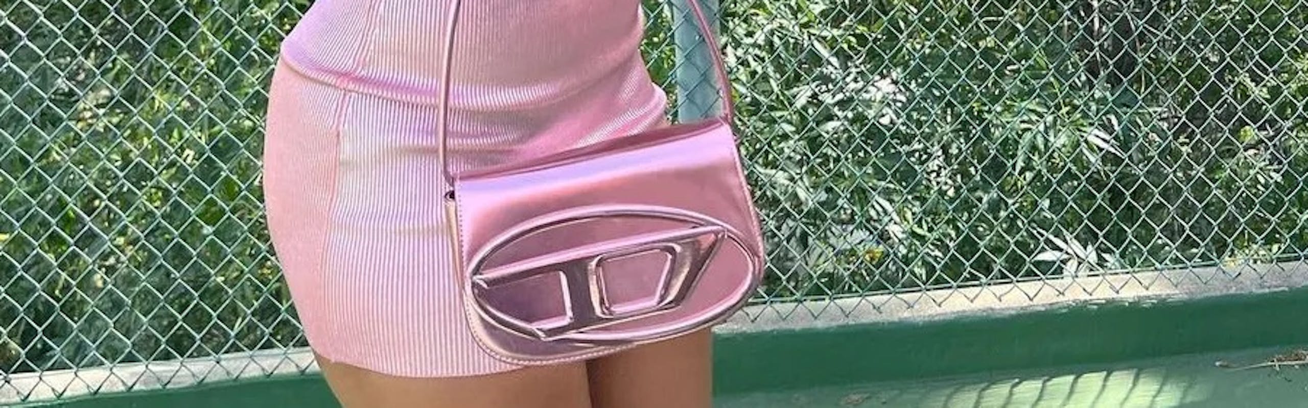 Megan The Stallion wears baby pink Diesel dress while holding matching DR1 Bag.