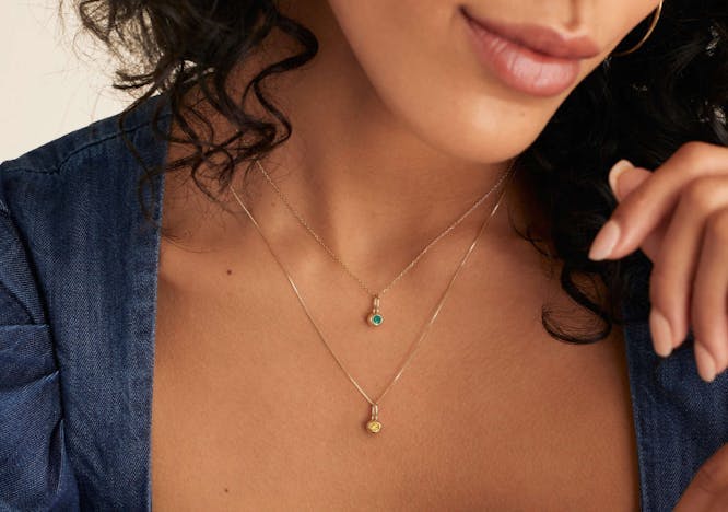 Mejuri jewelry featuring emerald pendant.