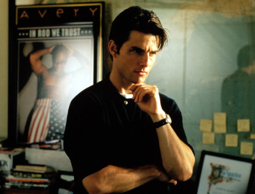 Tom Cruise standing in front of sports posters