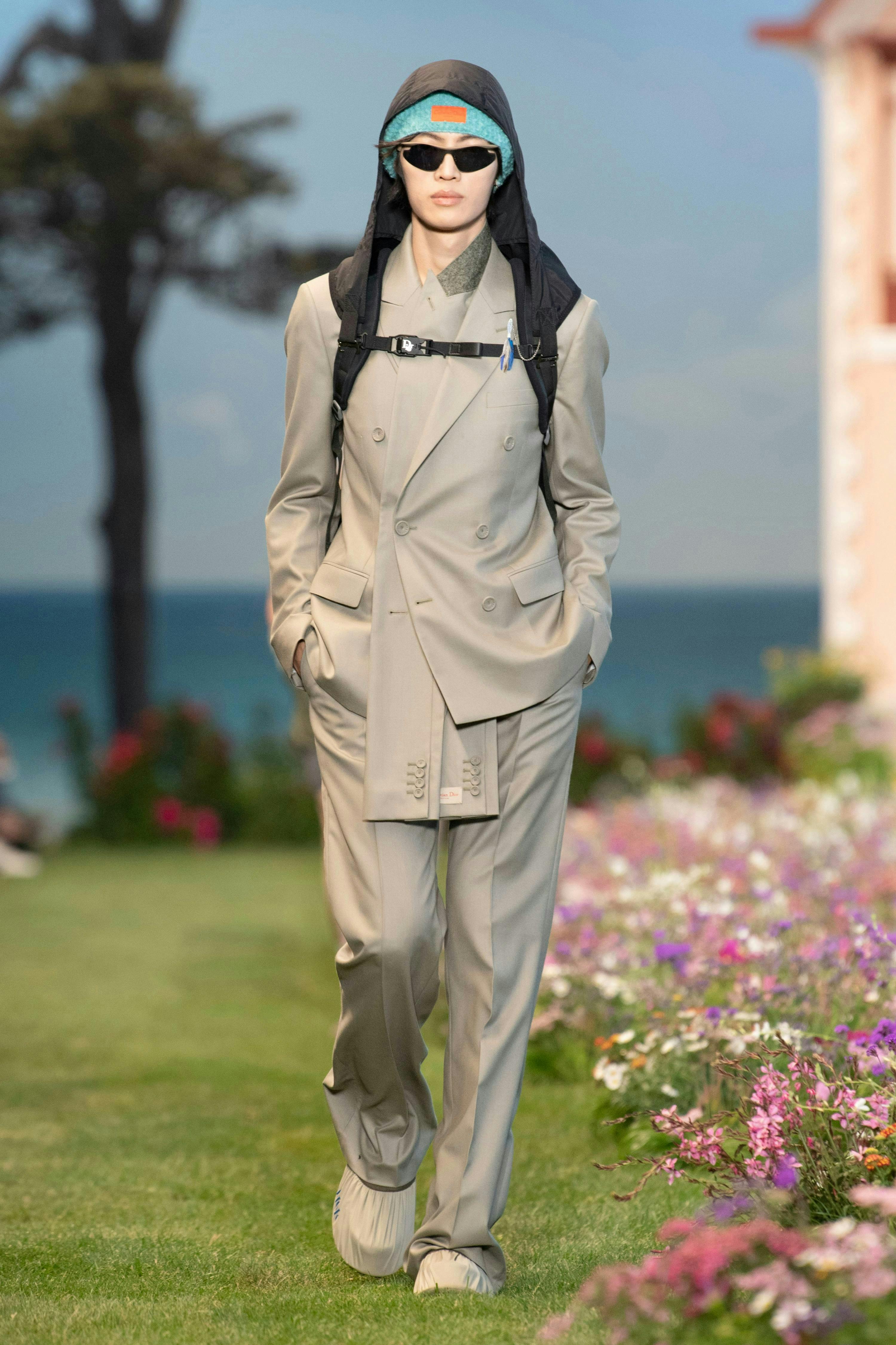 clothing apparel coat overcoat sunglasses accessories person suit grass plant