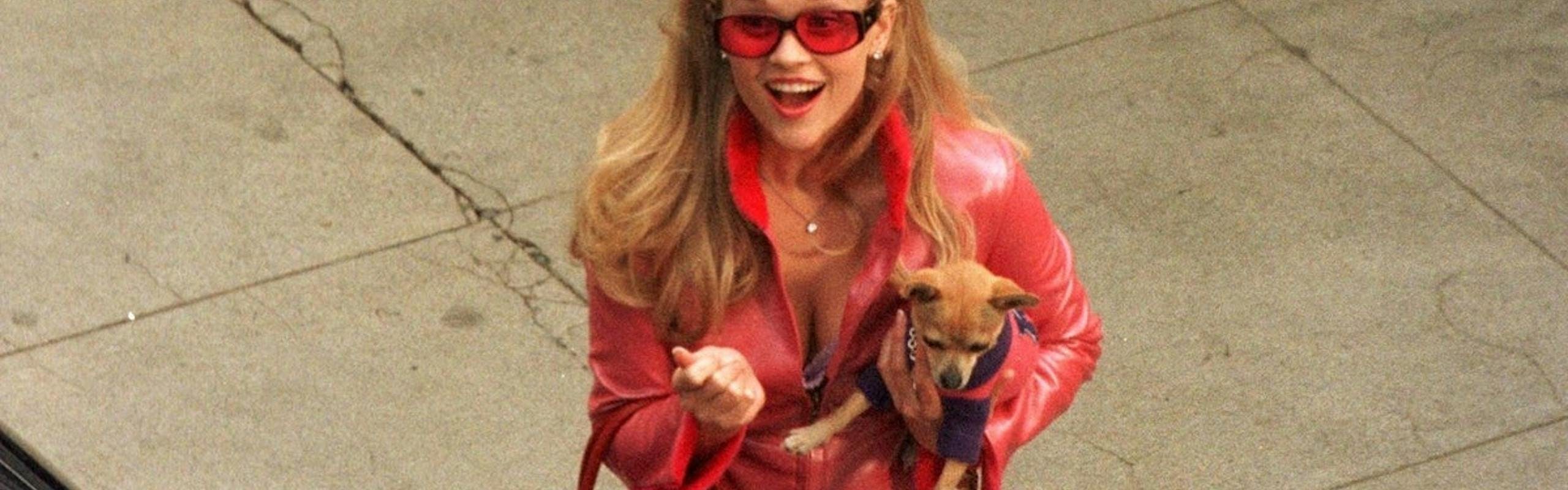 Elle Woods rocking the Barbiecore trend on set of Legally Blonde in a pink leather outfit. 