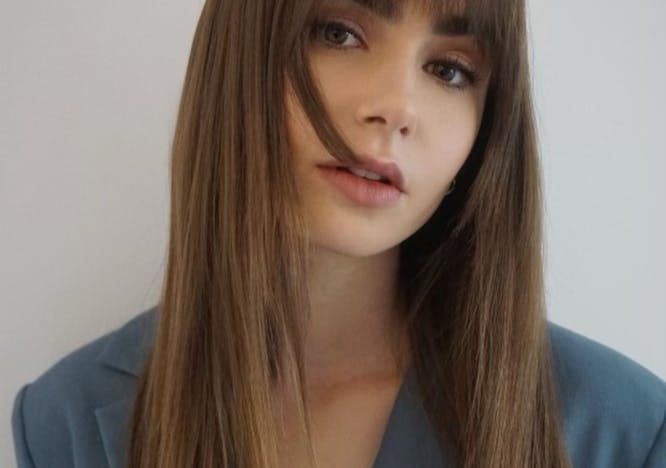 Lily Collins in a blue suit jacket and styled, straight hair.