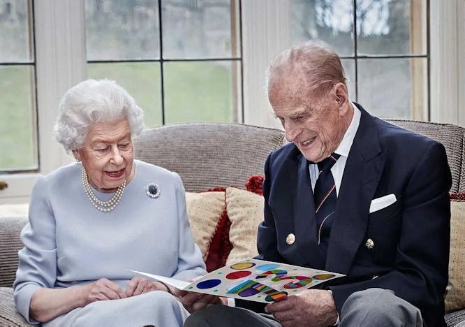 queen elizabeth and prince philip beside each other looking at a folder