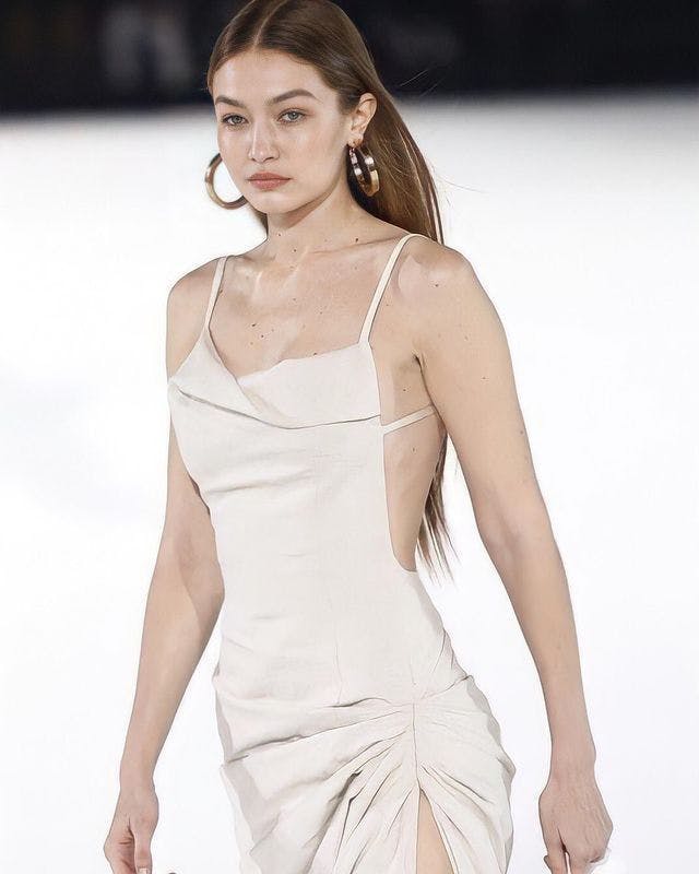 Gigi Hadid wearing a cream-colored slip dress at a runway show