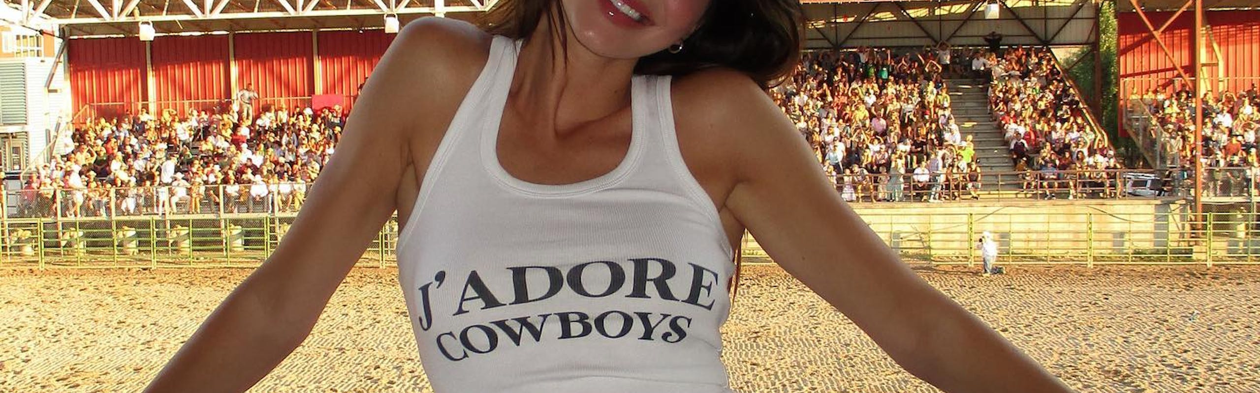Kendall Jenner wearing a fitted tank top that says "J'Adore Cowbodys" and a denim mini skirt
