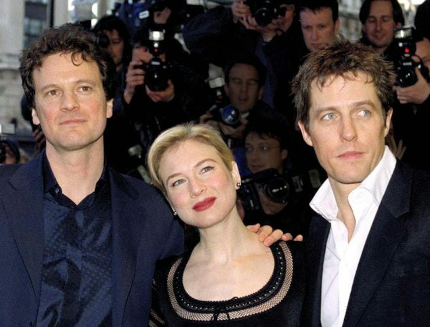 Colin Firth, Renée Zellweger, and Hugh Grant pose for a photo on a red carpet together.
