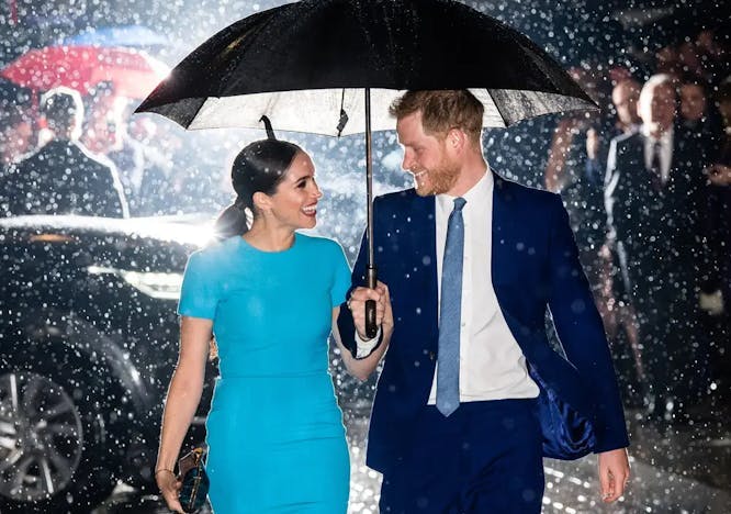 Prince Harry and Meghan Markle share an umbrella.