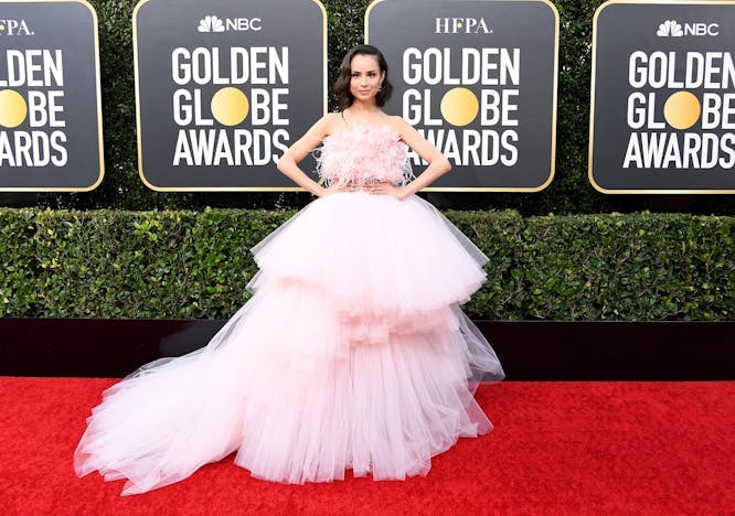 Sofia Carson at the 2021 Golden Globes wearing a pink tulle ballgown with a feathered bodice.