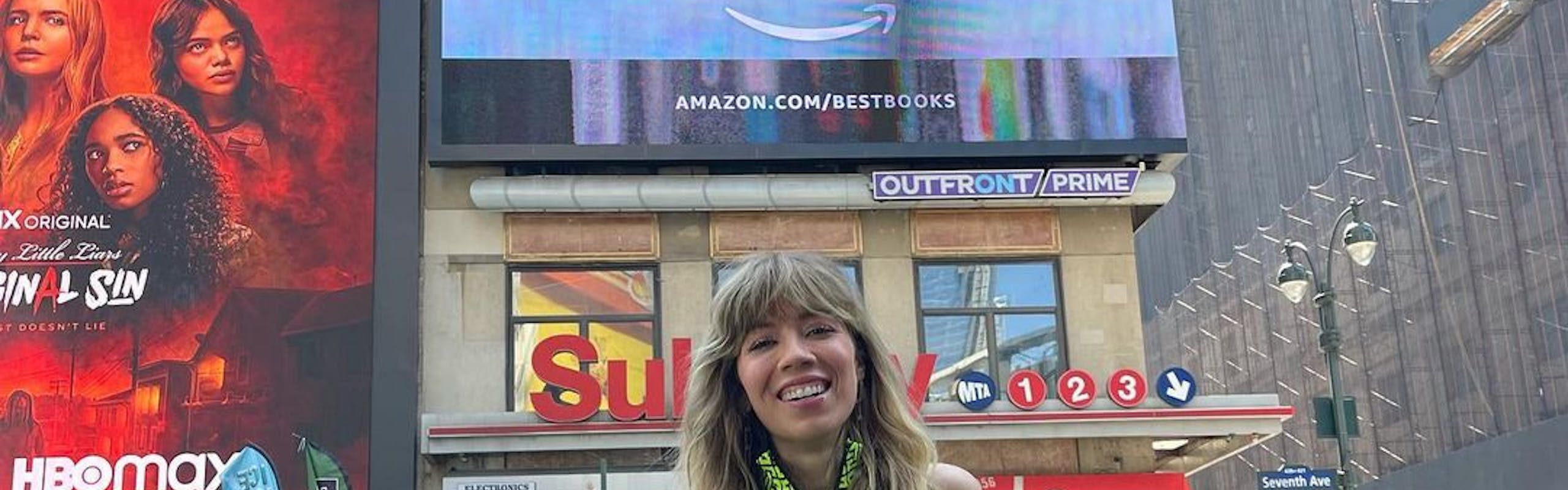 Jennette McCurdy standing under a billboard of her memoir “I’m Glad My Mom Died.”