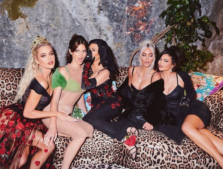 The Kar-Jenner sisters pose for a photo on a leopard couch.