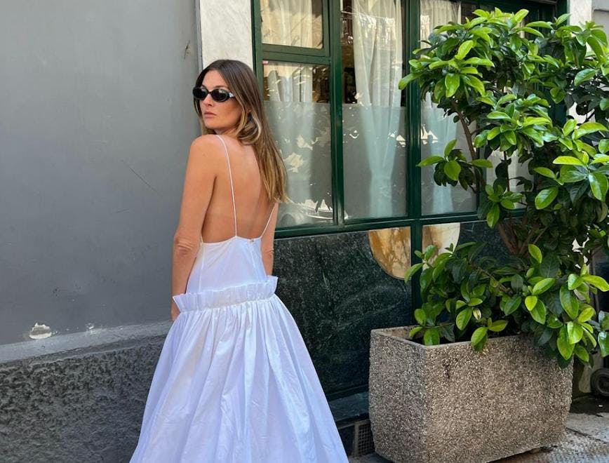Camille Charrière in a white dress and sunglasses