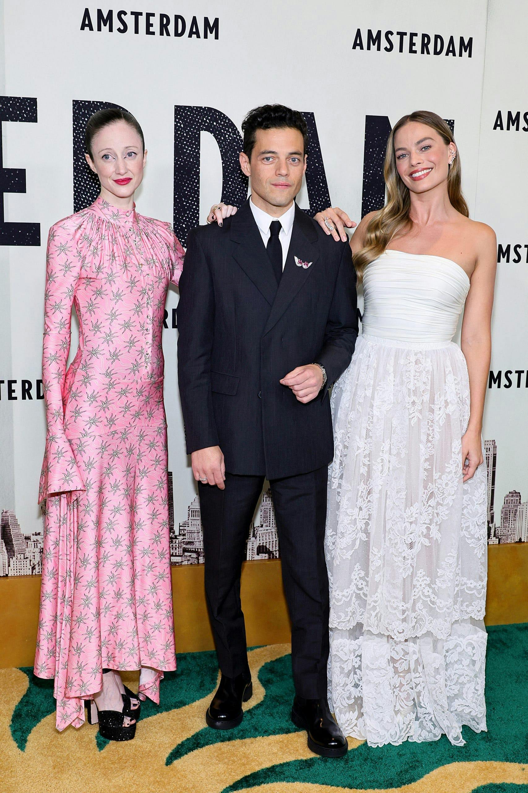 Andrea Riseborough, Rami Malek, and Margot Robbie on a white background