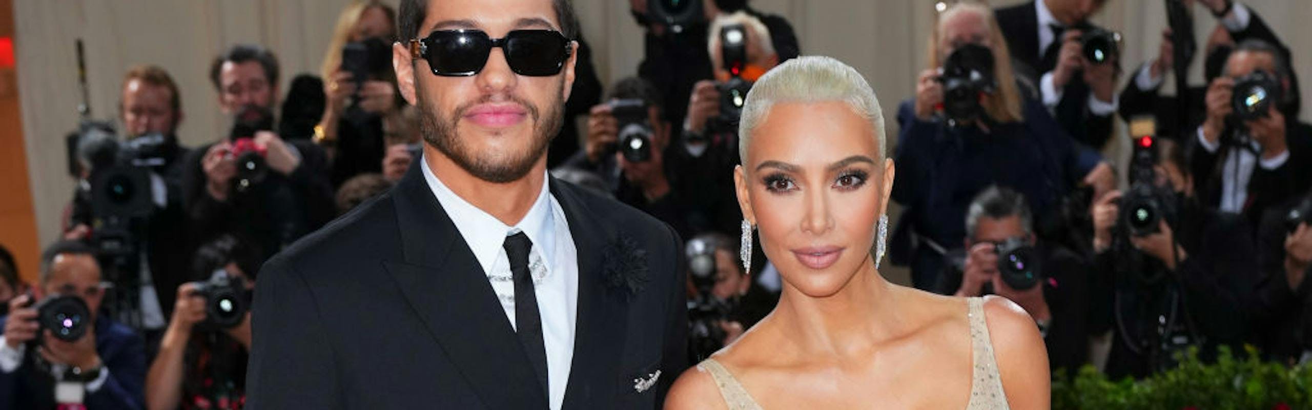 Pete Davidson in a black suit and Kim Kardashian in a sequined nude gown.