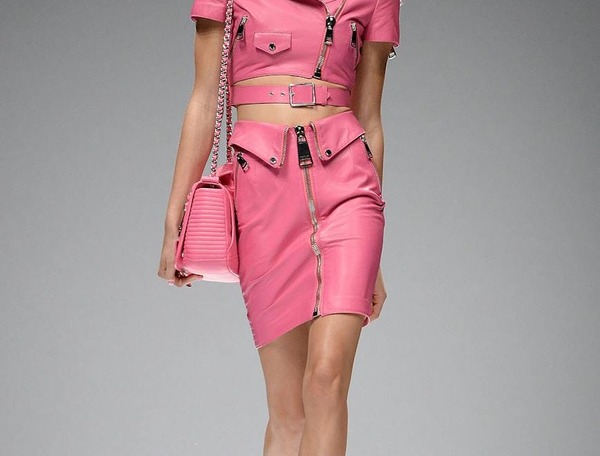 model in matching pink top and skirt holding pink barbie bag