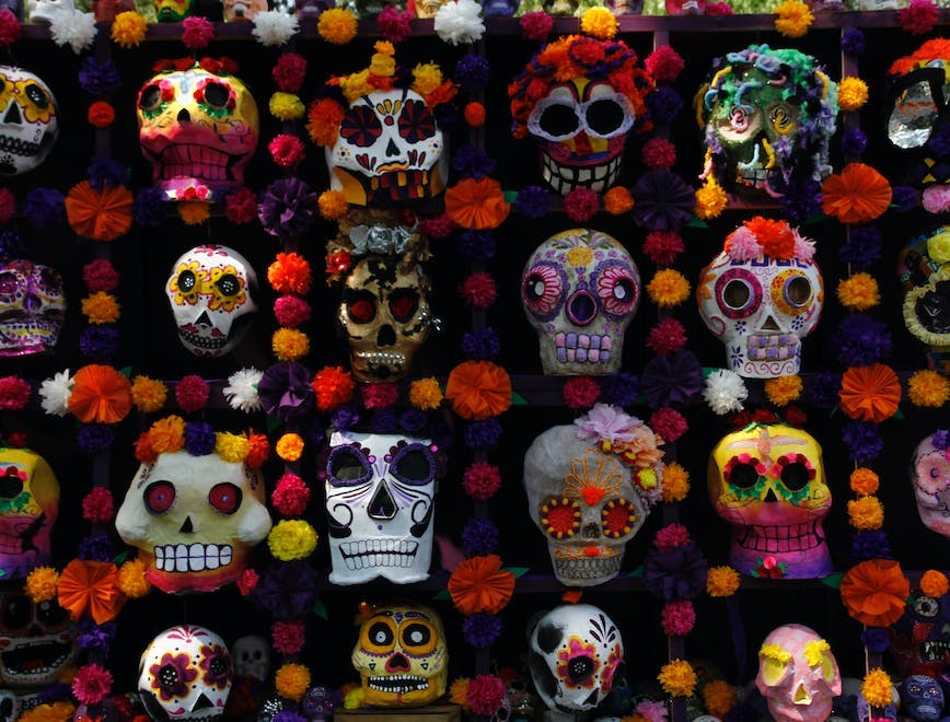Sugar Skulls attached on a wall with flowers.