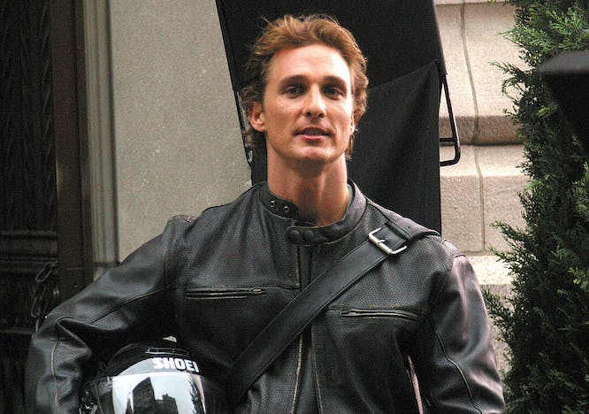 matthew mcconaughey wearing a leather jacket holding a motorcycle helmet