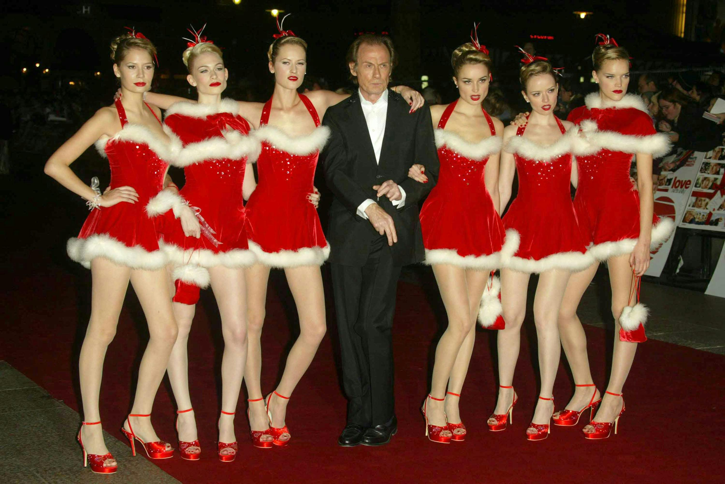 Bill Nighy will 6 dancers dressed in red Santa dresses