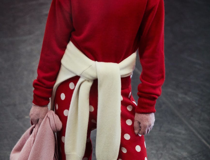 Model wearing red sweater and polka dots pants