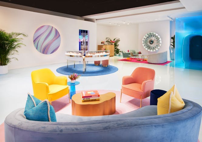 white room with yellow and pink chair blue couch blue wall art