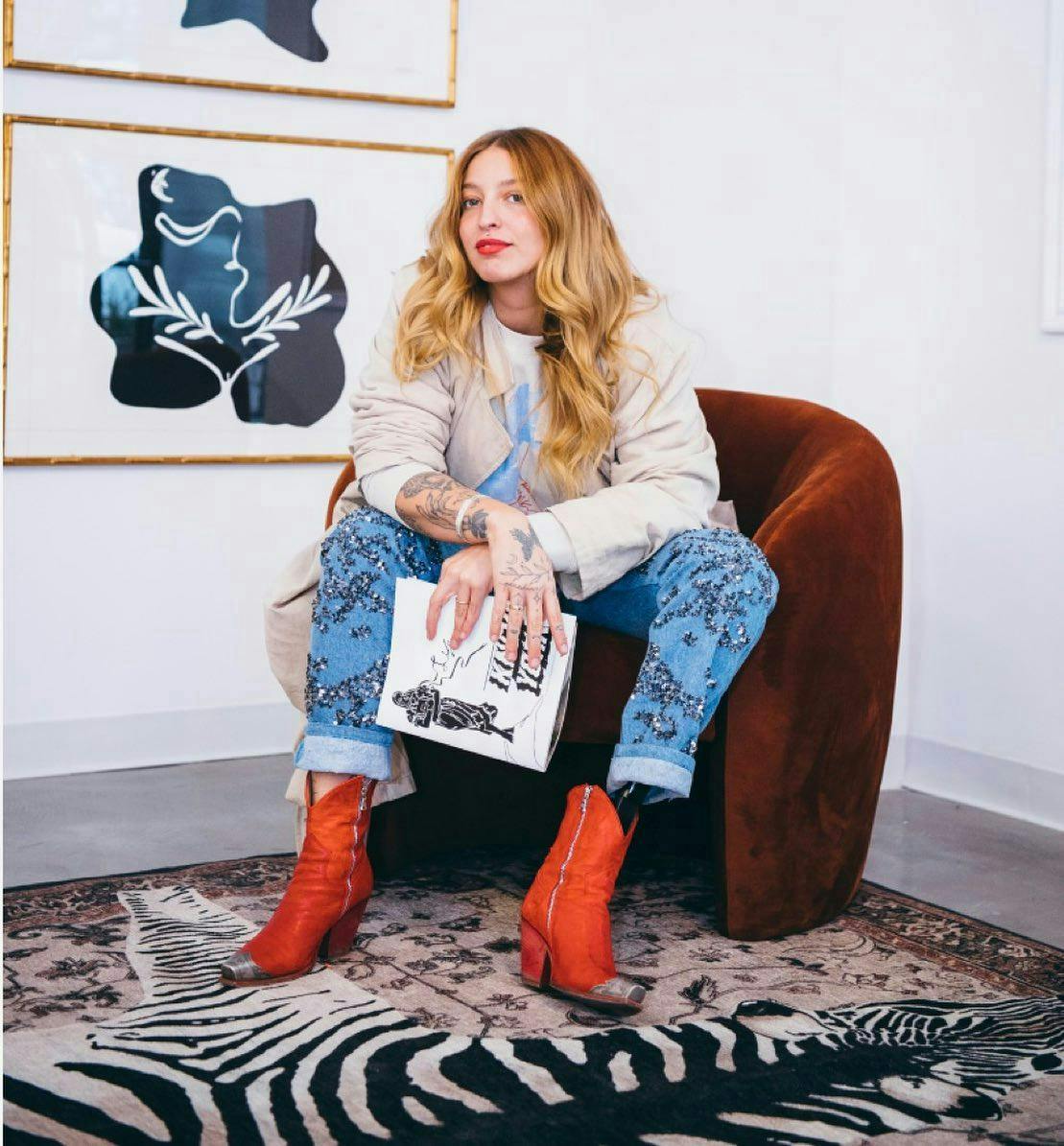 woman in a red chair red boots zebra carpet white walls