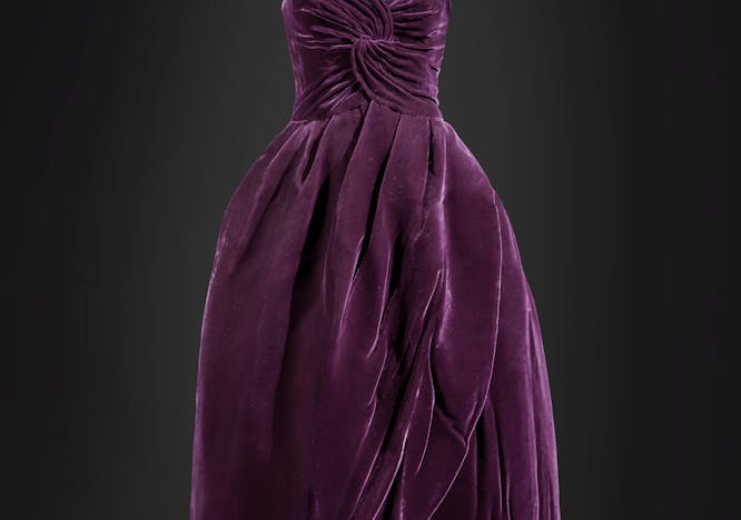 A purple dress set against a dark grey backdrop.