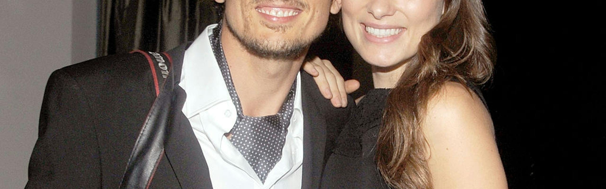 A man in a black and white suit next to a woman in a black dress.