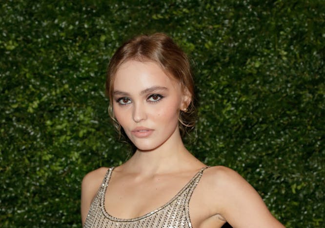 Lily-Rose Depp in a sheer sequined dress looking at the camera.