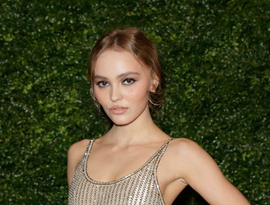 Lily-Rose Depp in a sheer sequined dress looking at the camera.