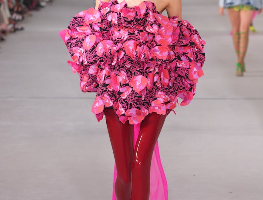 A model in a floral dress and latex red tights.
