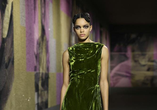 Model wears velvet green, high-neck dress.