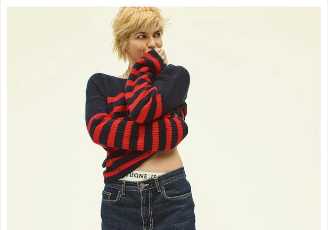 Woman in striped sweater with dark-wash jeans.