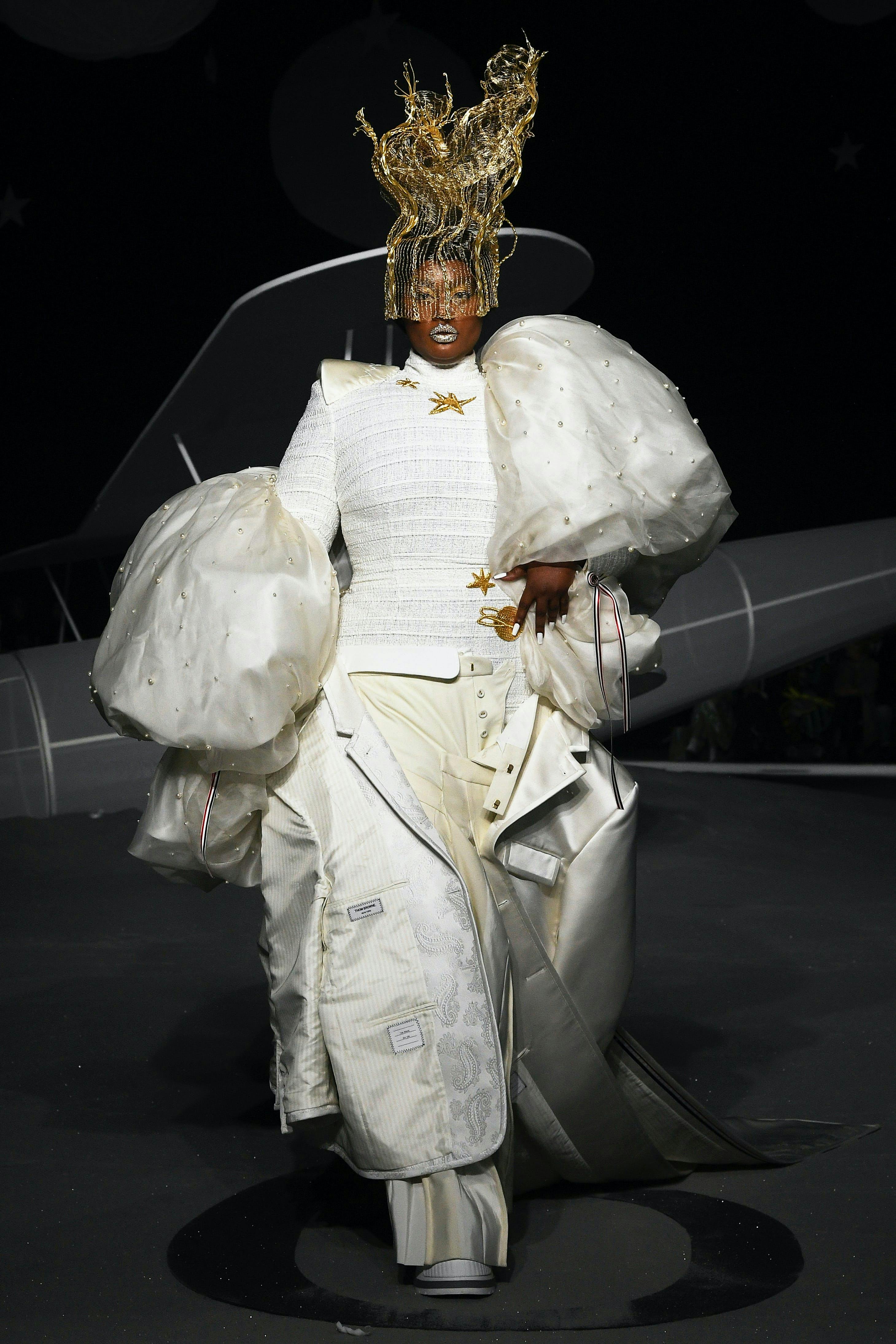 A model in a white outragoes Thom Browne runway look.