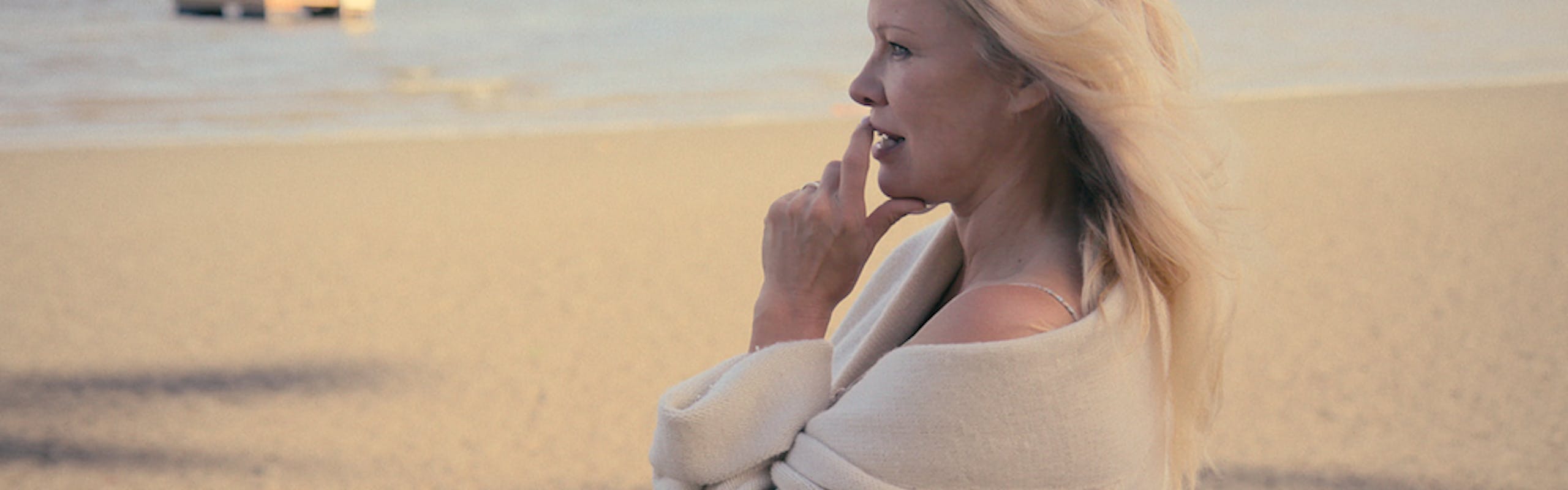 Pamela Anderson wears a beige robe.