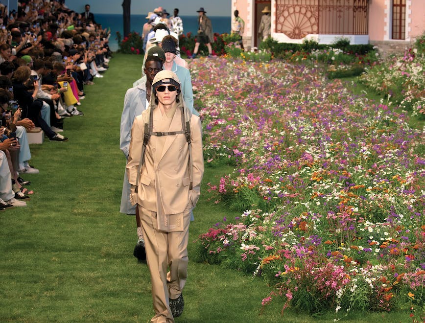 Dior Men's Collection runway on green grass.