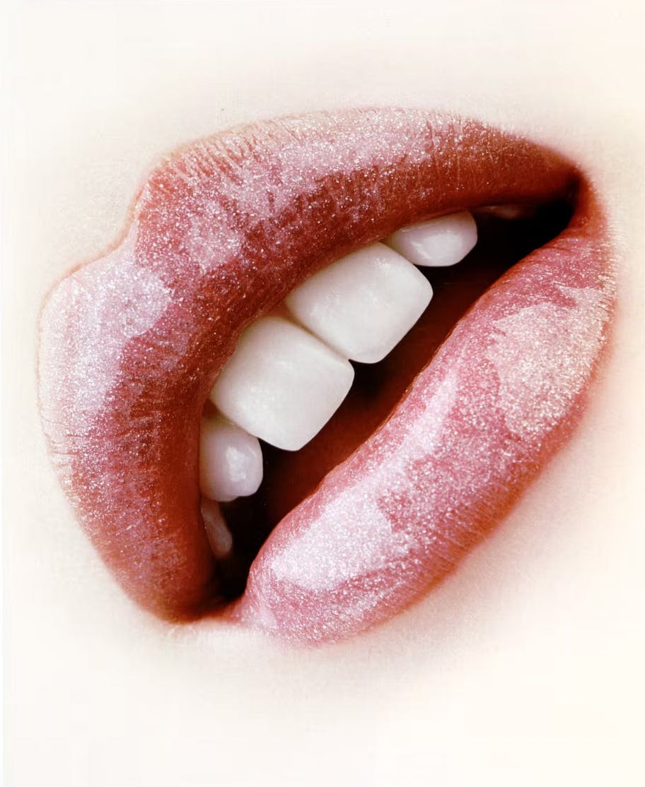 A picture of a mouth and teeth with sparkly lipgloss.