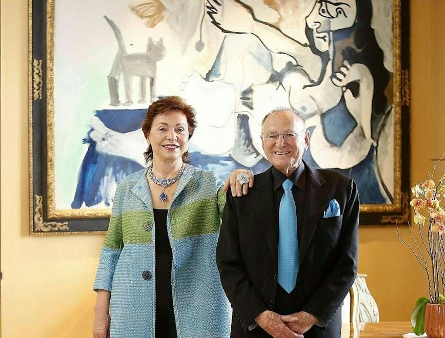 A woman and man standing in front of a painting.