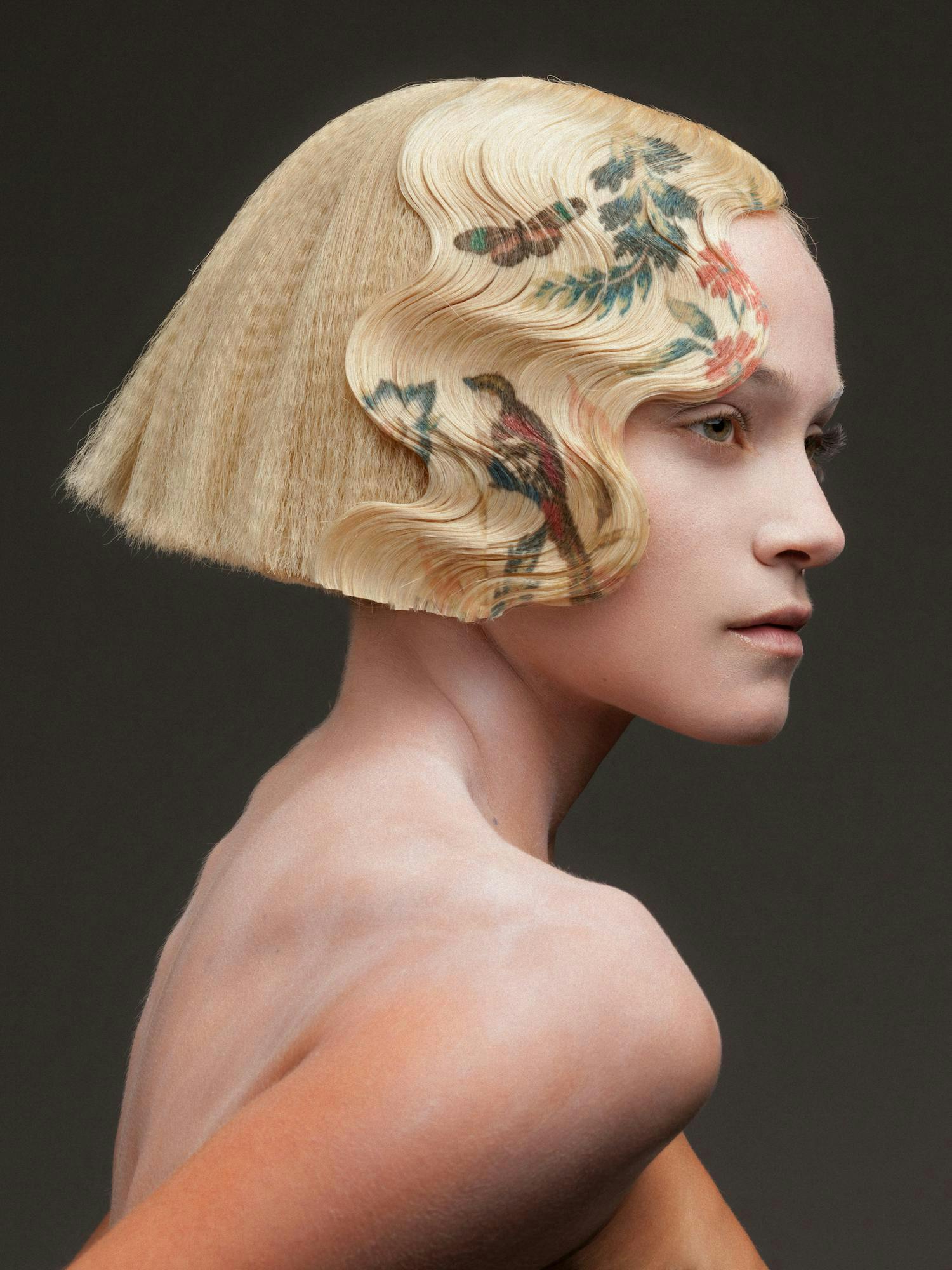 Blonde model with graphic designs on her hair.