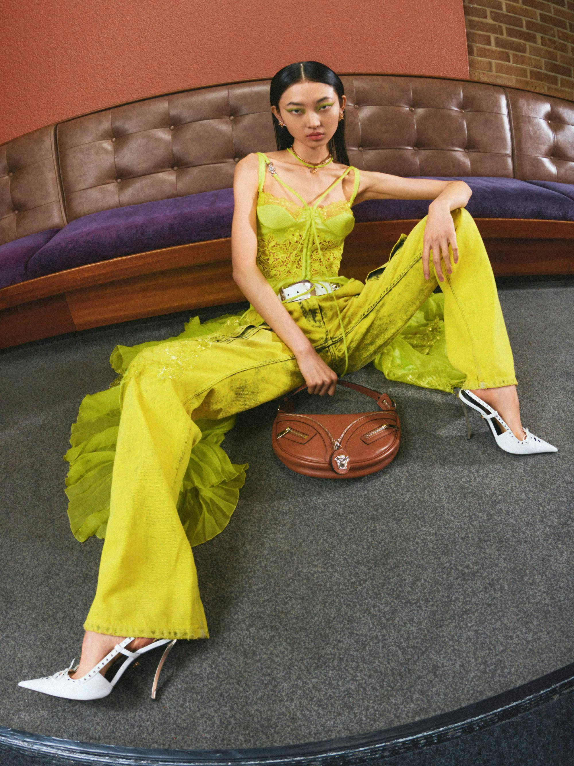 Model in lime green body suit and white heels.